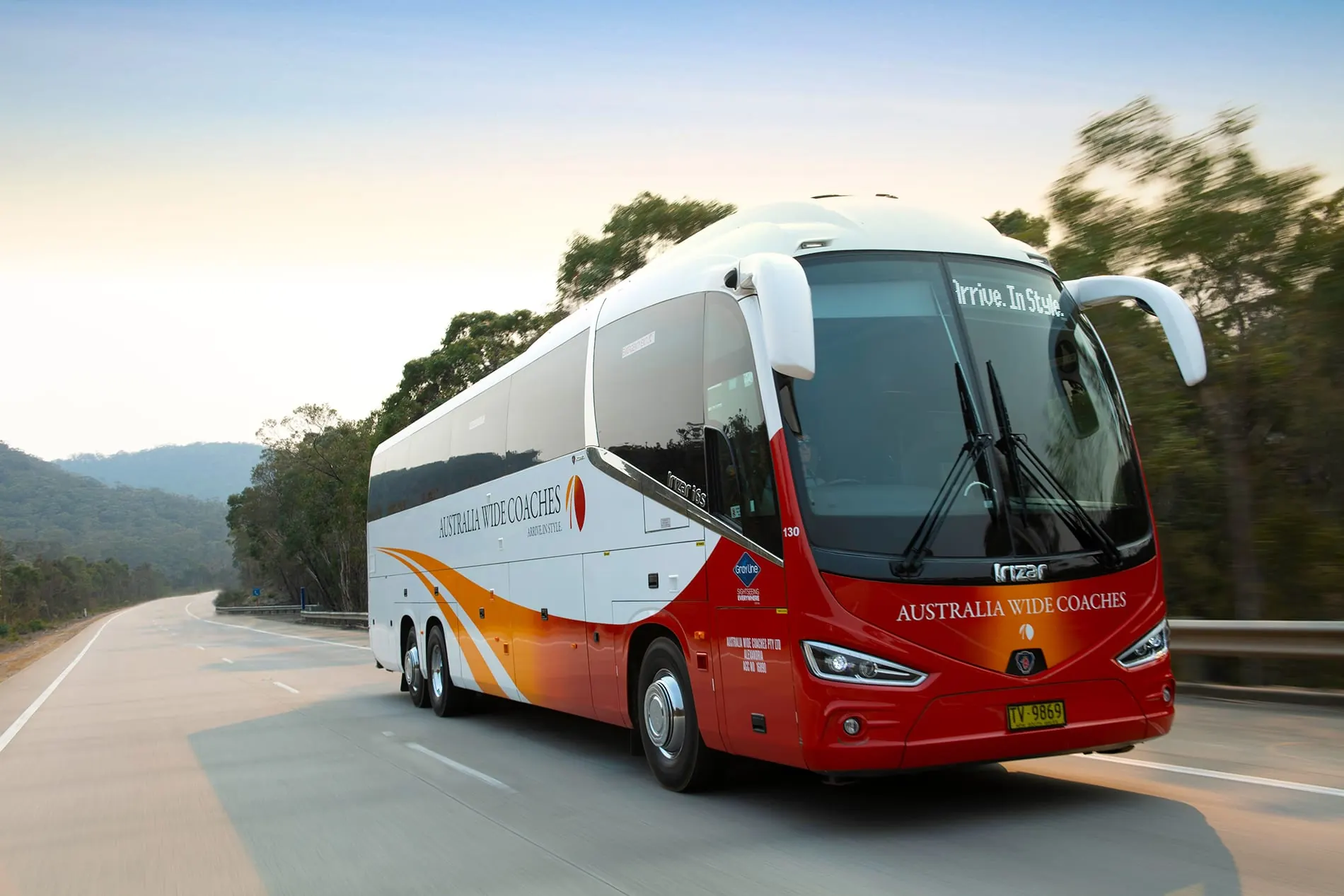An Australia Wide Coaches luxury coach on a bushland highway